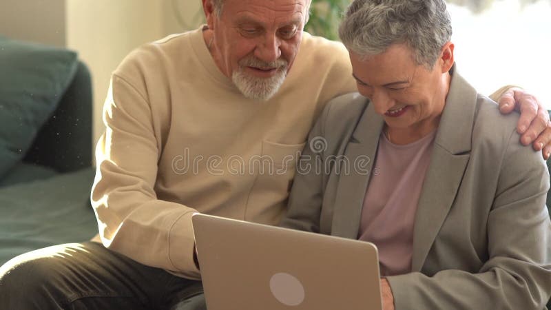 Högre par hemma med en bärbar dator. pensionerad familj som arbetar med datorinlärning i sociala medier. datorkunskap bland