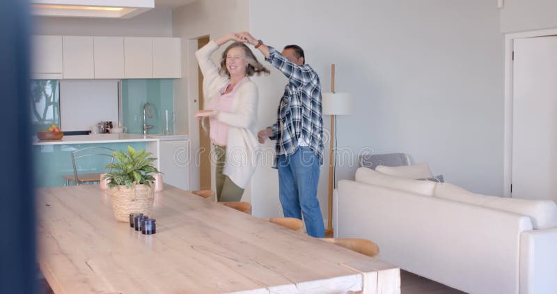 Högre par som dansar tillsammans i det moderna vardagsrummet och som har semestertid stock video