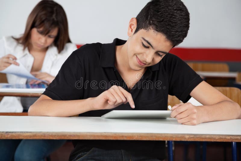 Högstadiumstudent Using Digital Tablet på skrivbordet
