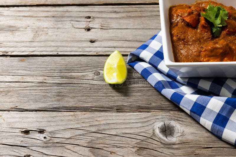 Högvinkelsikt av köttgrå som serveras i tarm med napkin och citronsegment på träbord. Begreppet "färsk citrusfrukt och färsk mjöl" i obearbetade livsmedel.