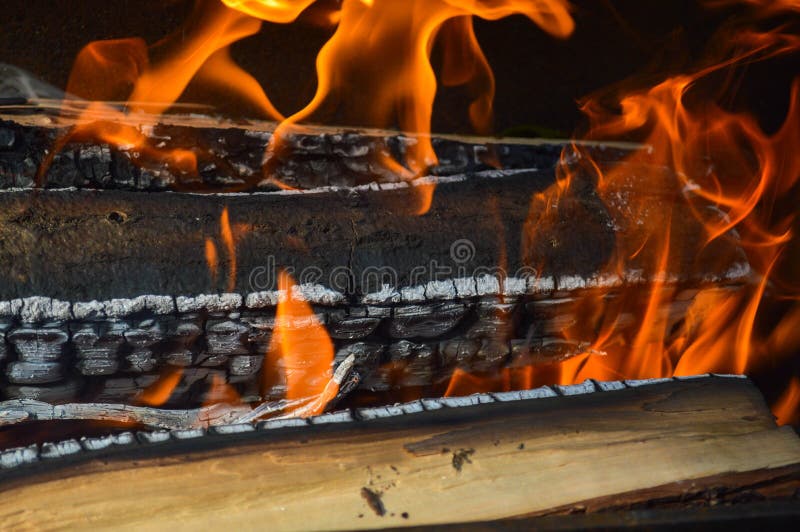 Hölzerne brennende heiße verkohlte Planken des Holzes meldet ein Feuer mit den Zungen des Feuers und des Rauches an Beschaffenhei stockfotografie Hölzerne brennende heiße verkohlte Planken des Holzes meldet ein Feuer mit den Zungen des Feuers und des Rauches an Beschaffenhei stockfotografie