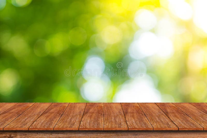 Hölzerne Tischplatte auf bokeh Zusammenfassungs-Grünhintergrund