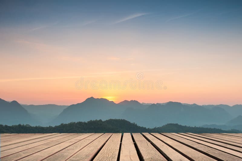 Hölzerne Tischplatte auf majestätischem Sonnenuntergang in den Bergen gestalten landschaftlich stockbild Hölzerne Tischplatte auf majestätischem Sonnenuntergang in den Bergen gestalten landschaftlich stockbild