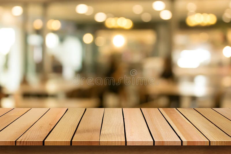 Hölzerne Tischplatte auf Unschärfe bokeh Caféhintergrund kann für DIS benutzt werden