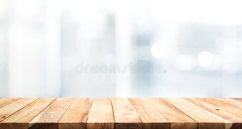 Hölzerne Tischplatte auf Unschärfeglasfensterwandgebäudehintergrund
