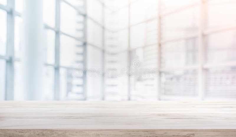 Hölzerne Tischplatte auf Unschärfeweißem Glasfensterhintergrundformbüro