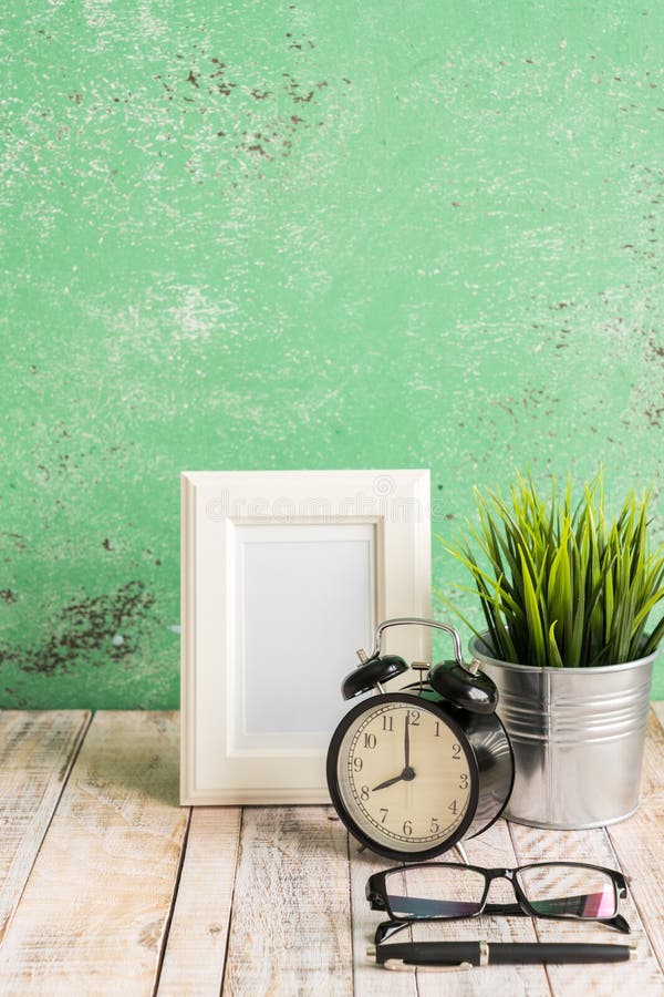 Hölzerner Arbeitsplatzdesktop mit Uhr; Anlagen; Gläser; Rahmen und stockfotografie Hölzerner Arbeitsplatzdesktop mit Uhr; Anlagen; Gläser; Rahmen und stockfotografie