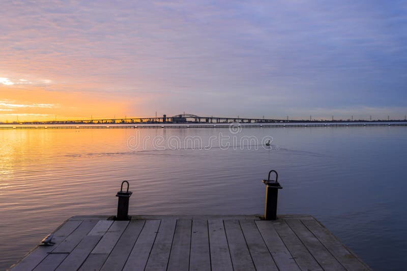 Hölzerner Bootspier, der heraus zu vibrierenden bunten Sonnenaufgang über tr führt stockfotos Hölzerner Bootspier, der heraus zu vibrierenden bunten Sonnenaufgang über tr führt stockfotos