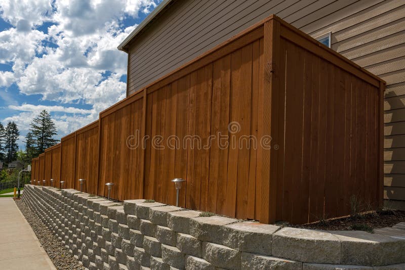 Hölzerner Zaun und Betonblock-Stützmauer