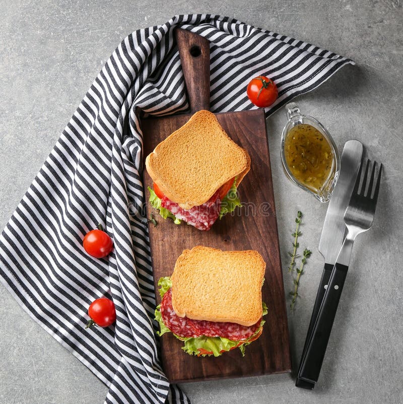 Hölzernes Brett mit köstlichen Sandwichen auf Tabelle, lizenzfreie stockfotografie Hölzernes Brett mit köstlichen Sandwichen auf Tabelle, lizenzfreie stockfotografie
