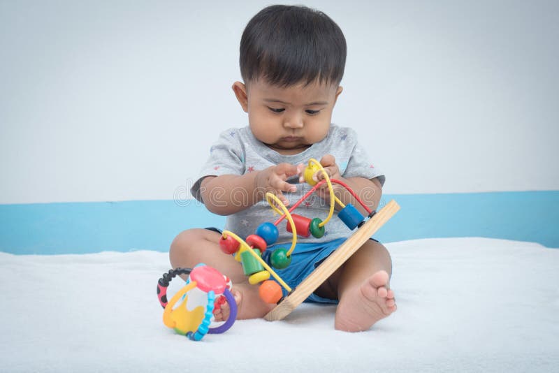 hölzernes Spielzeug des wenig asiatischen Babyspiels stockfotografie hölzernes Spielzeug des wenig asiatischen Babyspiels stockfotografie