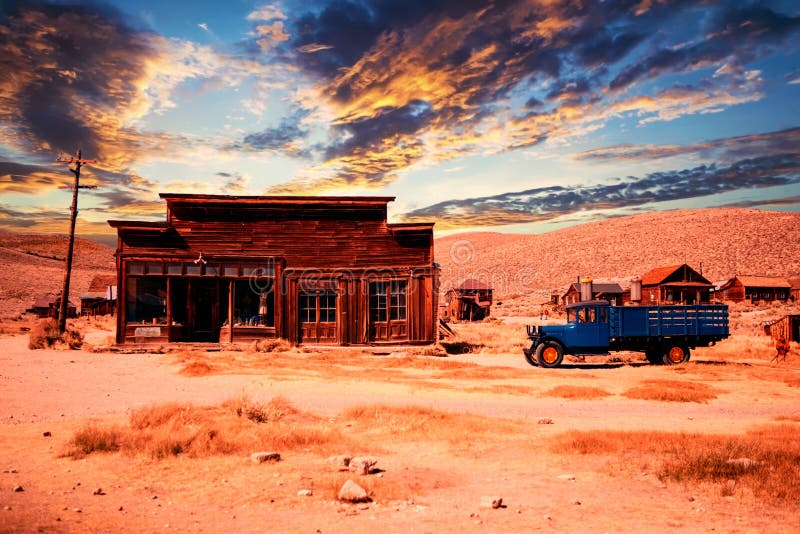 Hölzernes verlassenes Haus mit Auto in der Wüste bei Sonnenuntergang lizenzfreies stockfoto Hölzernes verlassenes Haus mit Auto in der Wüste bei Sonnenuntergang lizenzfreies stockfoto