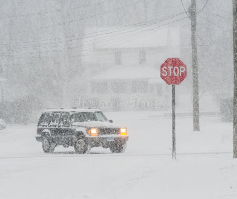 Red stop sign on snow covered road car slipping and sliding. Red stop sign on snow covered road car slipping and sliding