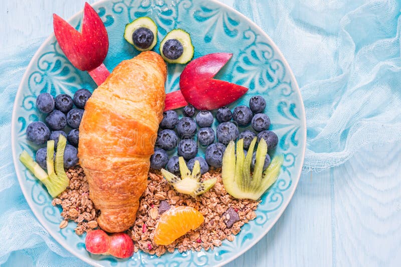 Hörnchen mit Beeren zum lustiges Kinderfrühstück lizenzfreie stockbilder Hörnchen mit Beeren zum lustiges Kinderfrühstück lizenzfreie stockbilder