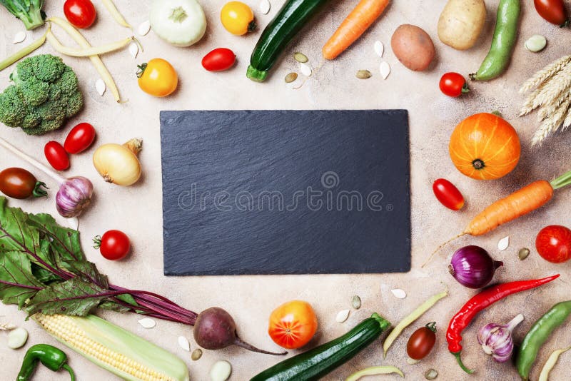 Autumn farm vegetables, root crops and slate cutting board top view with copy space for menu or recipe. Healthy and organic food background. Autumn farm vegetables, root crops and slate cutting board top view with copy space for menu or recipe. Healthy and organic food background.