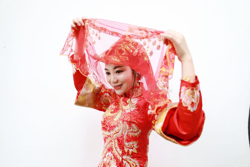 Hübsche asiatische chinesische schöne Braut mit traditionellem chinesischem rotem Kleid der Hochzeit und roten Hauptabdeckungen stockfotografie Hübsche asiatische chinesische schöne Braut mit traditionellem chinesischem rotem Kleid der Hochzeit und roten Hauptabdeckungen stockfotografie