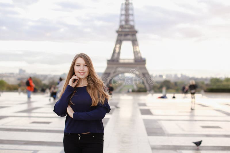 Hübsche Frau, die im Eiffelturmhintergrund in Paris steht