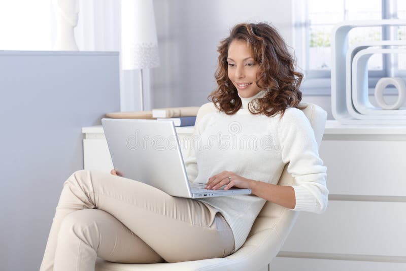 Hübsche Frau, die zu Hause Laptop-Computer verwendet stockfotografie