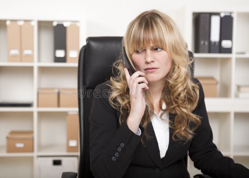Hübsche Geschäftsfrau, die auf einen Telefonanruf hört stockfoto Hübsche Geschäftsfrau, die auf einen Telefonanruf hört stockfoto