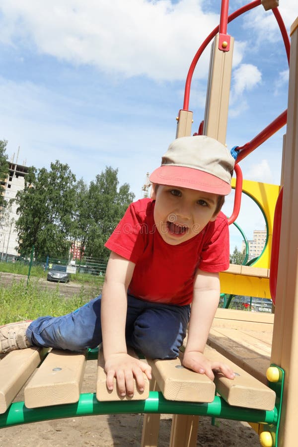 Hübsche Haltungen des kleinen Jungen auf Spielplatz stockbild Hübsche Haltungen des kleinen Jungen auf Spielplatz stockbild