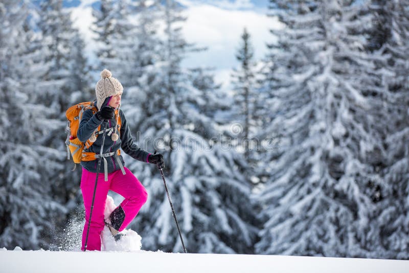 Hübsche, junge Frau, die im Hochgebirge snowshoeing ist stockbild Hübsche, junge Frau, die im Hochgebirge snowshoeing ist stockbild