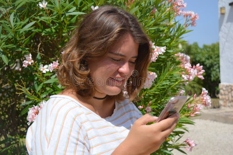 Hübsche junge Frau draußen, unter Verwendung eines Smartphone stockfotografie Hübsche junge Frau draußen, unter Verwendung eines Smartphone stockfotografie