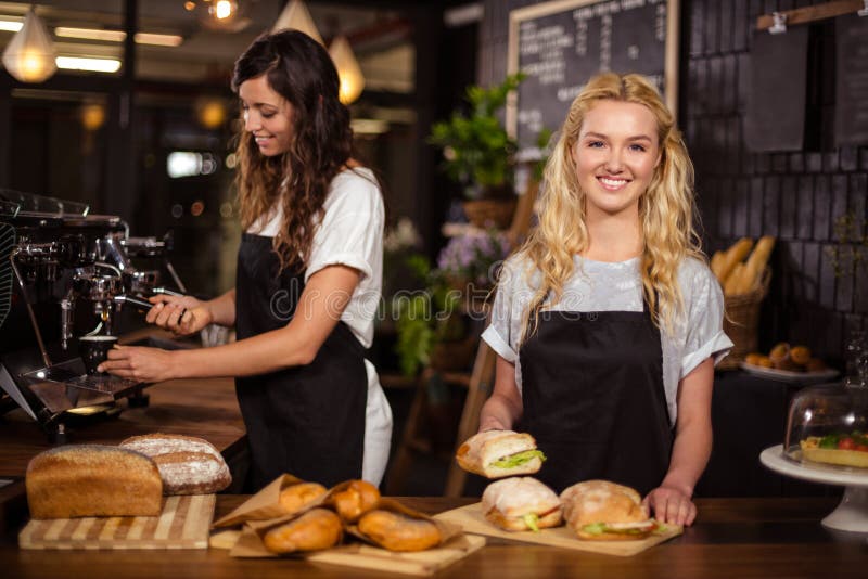 Hübsche Kellnerinnen hinter dem Gegenarbeiten lizenzfreies stockfoto Hübsche Kellnerinnen hinter dem Gegenarbeiten lizenzfreies stockfoto
