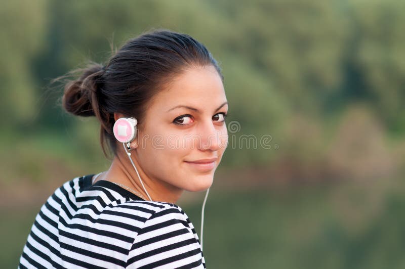 Hübsche lächelnde Jugendliche hört Musik