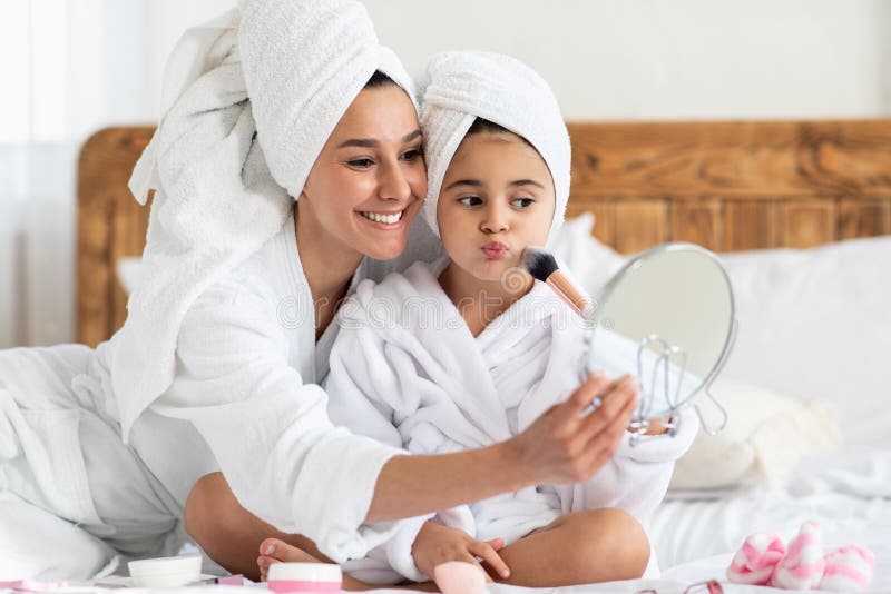 Hübsche Mutter Anwendung erröten auf ihr Kind Wange lizenzfreies stockbild