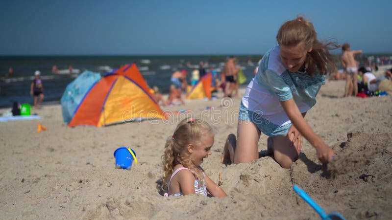 Hübsche Mutter, Die Ihre Kleine Tochter in Sand am Strand Graben Verwirrte Stock Footage - Video von hintergrund, hand: 169246620->