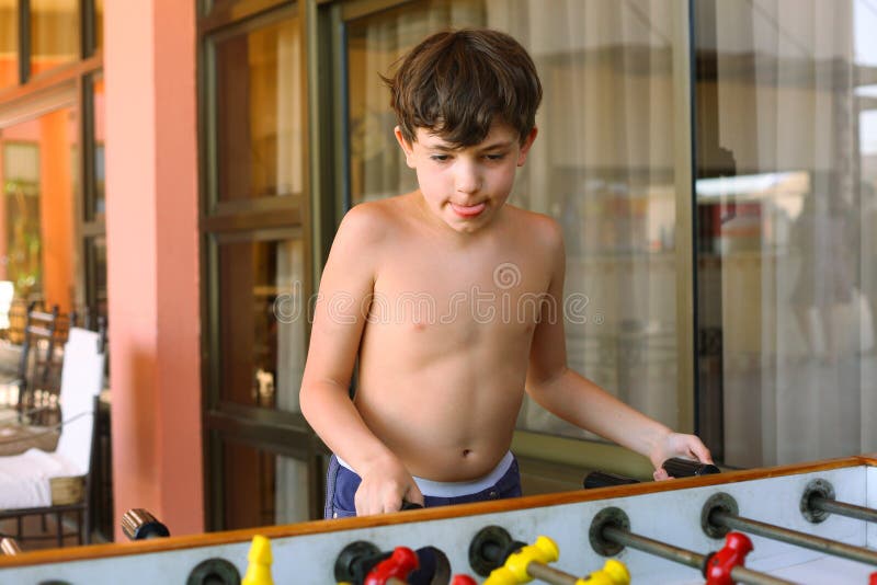 Hübscher jugendlicher Jungenspiel-Tabellenfußball im Strandurlaubsorthotel rec stockbilder Hübscher jugendlicher Jungenspiel-Tabellenfußball im Strandurlaubsorthotel rec stockbilder