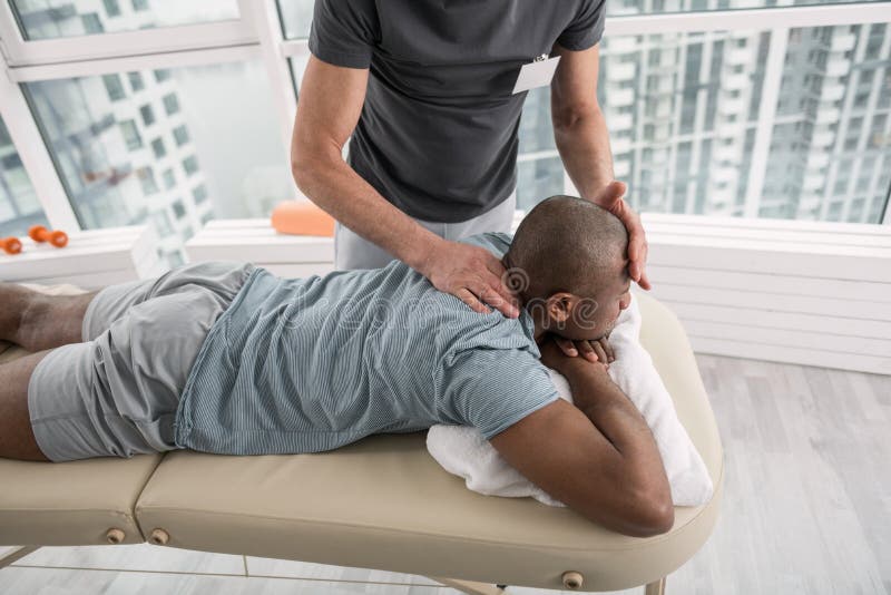 Hübscher junger Mann, der eine Massagetherapie hat stockfotos Hübscher junger Mann, der eine Massagetherapie hat stockfotos