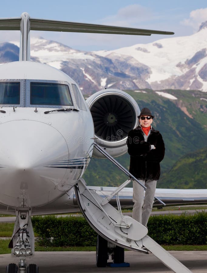 Hübscher moderner Mann auf den Schritten eines Privatjets stockfotografie Hübscher moderner Mann auf den Schritten eines Privatjets stockfotografie