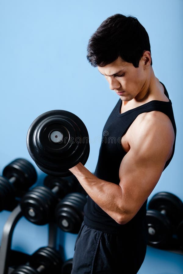 Hübscher muskulöser Sportler verwendet seinen Dumbbell lizenzfreie stockbilder Hübscher muskulöser Sportler verwendet seinen Dumbbell lizenzfreie stockbilder