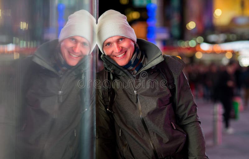 Hübscher tragender Mantel und Hut des jungen Mannes auf Hintergrund mit unscharfen Lichtern der Stadt nachts lizenzfreie stockfotografie Hübscher tragender Mantel und Hut des jungen Mannes auf Hintergrund mit unscharfen Lichtern der Stadt nachts lizenzfreie stockfotografie