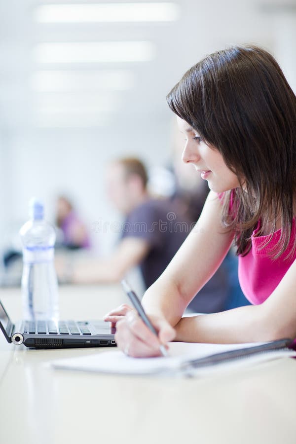 Hübscher weiblicher Kursteilnehmer mit Laptop und Büchern lizenzfreies stockbild