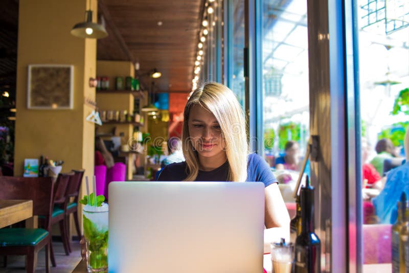 Hübscher weiblicher Lebensstil Blogger, der an Netzbuch während des Restes im Café arbeitet stockfotografie