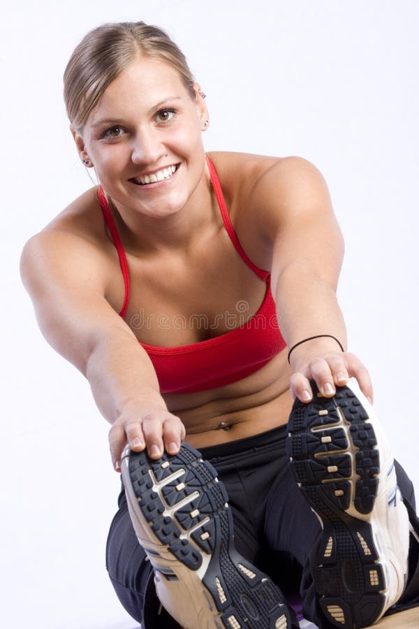 A pretty girl streching and smiling at the camera with a white background. A pretty girl streching and smiling at the camera with a white background