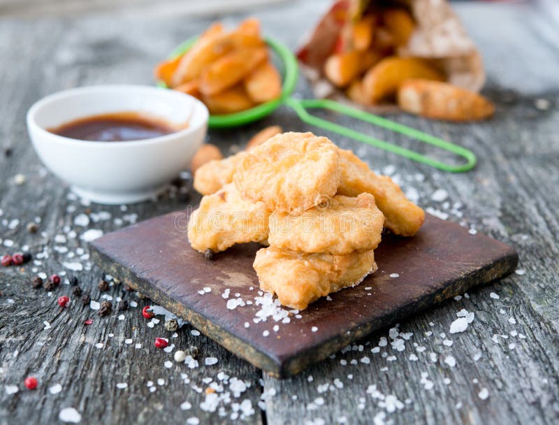 Hühnernuggets mit Soße auf rustikalem Hintergrund lizenzfreie stockbilder Hühnernuggets mit Soße auf rustikalem Hintergrund lizenzfreie stockbilder