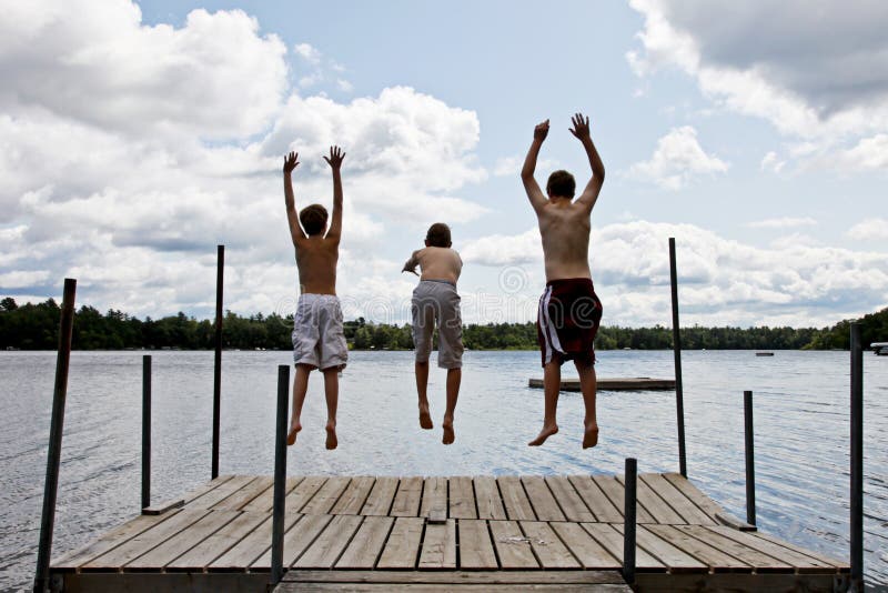 I bambini che saltano nel lago immagine stock libera da diritti I bambini che saltano nel lago immagine stock libera da diritti