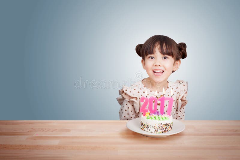 I bambini che si divertono al nuovo anno fanno festa con il dolce e la candela 2017 fotografia stock I bambini che si divertono al nuovo anno fanno festa con il dolce e la candela 2017 fotografia stock