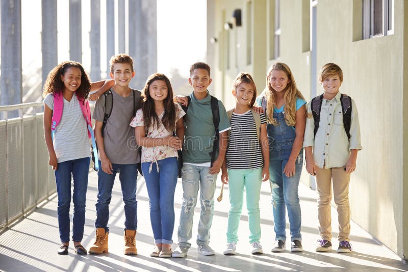 I bambini della scuola elementare stanno in corridoio che esamina la macchina fotografica immagine stock libera da diritti I bambini della scuola elementare stanno in corridoio che esamina la macchina fotografica immagine stock libera da diritti
