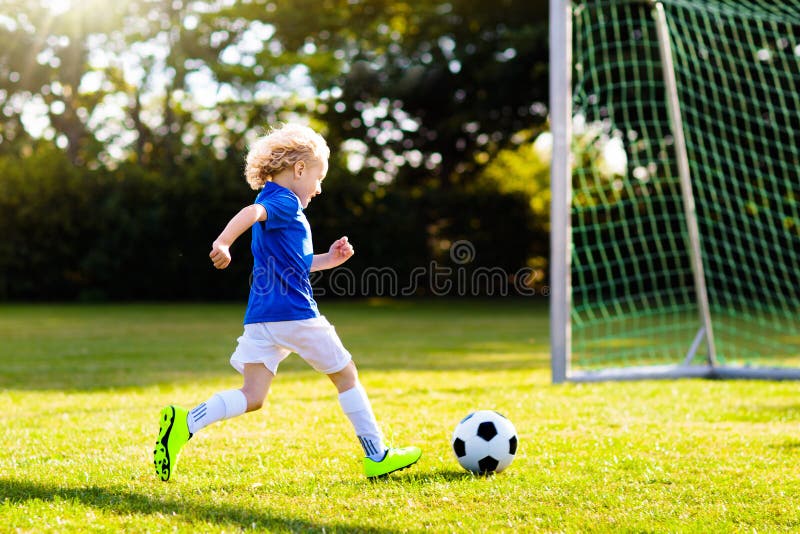 I bambini giocano a calcio Bambino al campo di calcio