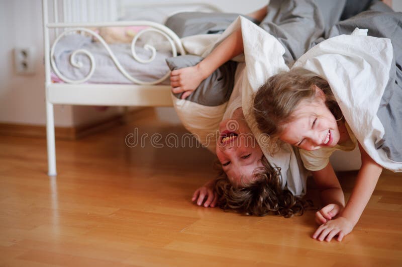 I bambini, il ragazzo e la ragazza concedono sul letto nella camera da letto
