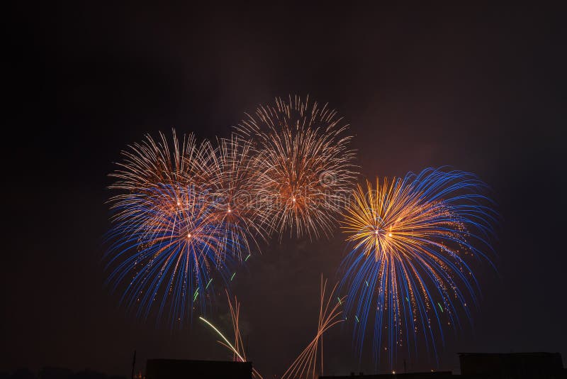 I bei fuochi d'artificio variopinti salutano contro il cielo notturno scuro immagini stock I bei fuochi d'artificio variopinti salutano contro il cielo notturno scuro immagini stock