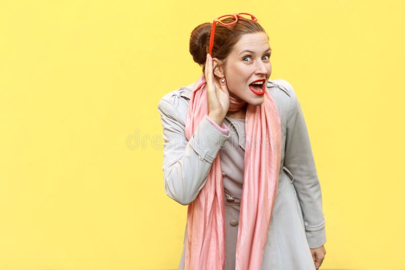 I can not hear you. Beautiful red head girl . Studio shot, yellow background royalty free stock image I can not hear you. Beautiful red head girl . Studio shot, yellow background royalty free stock image