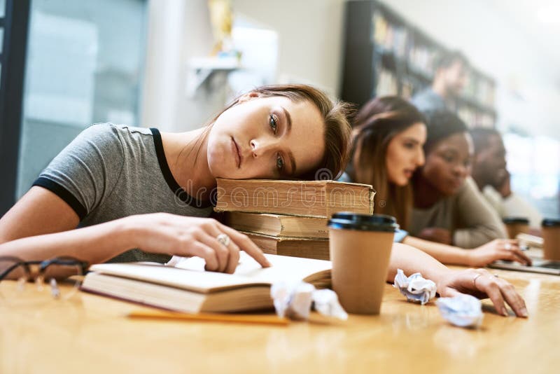 I cant college today. Please dont make me college. Portrait of a young woman looking tired while studying in a college royalty free stock photos