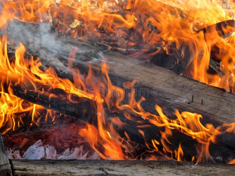 I ceppi di legno bruciano in una fiamma arancio con fumo immagine stock libera da diritti I ceppi di legno bruciano in una fiamma arancio con fumo immagine stock libera da diritti