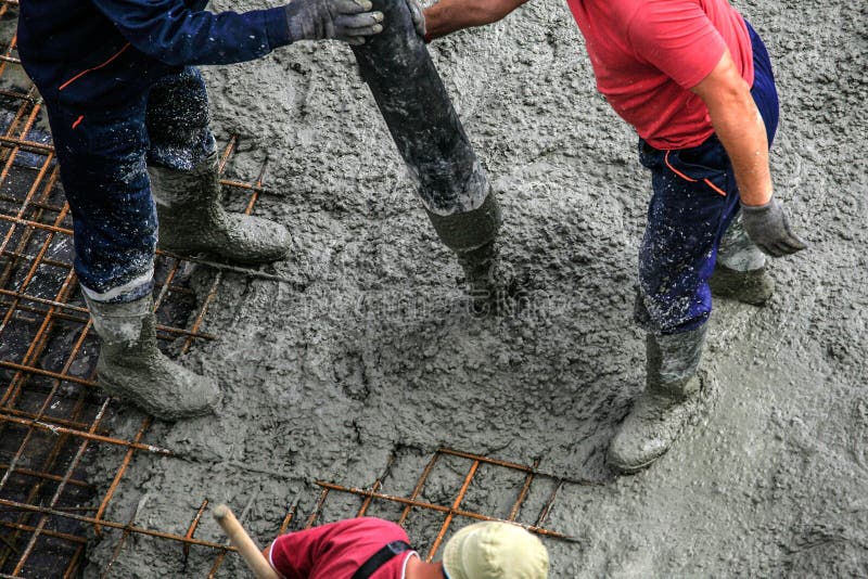 I costruttori lavora al cantiere: calcestruzzo di versamento per le FO immagine stock I costruttori lavora al cantiere: calcestruzzo di versamento per le FO immagine stock