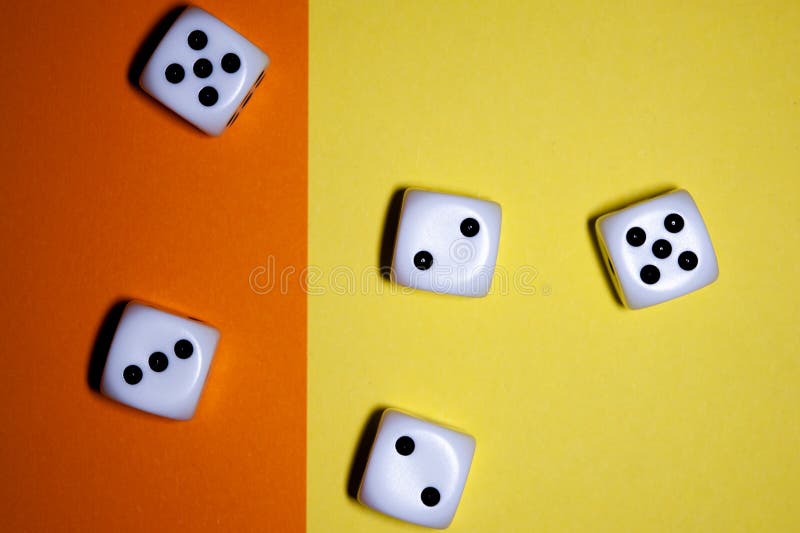 I dadi mettono su pianamente il fondo giallo ed arancio fotografie stock I dadi mettono su pianamente il fondo giallo ed arancio fotografie stock